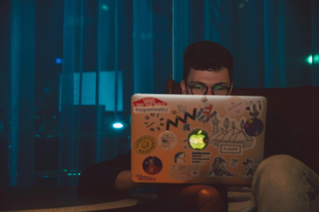 man working on laptop at night making money online